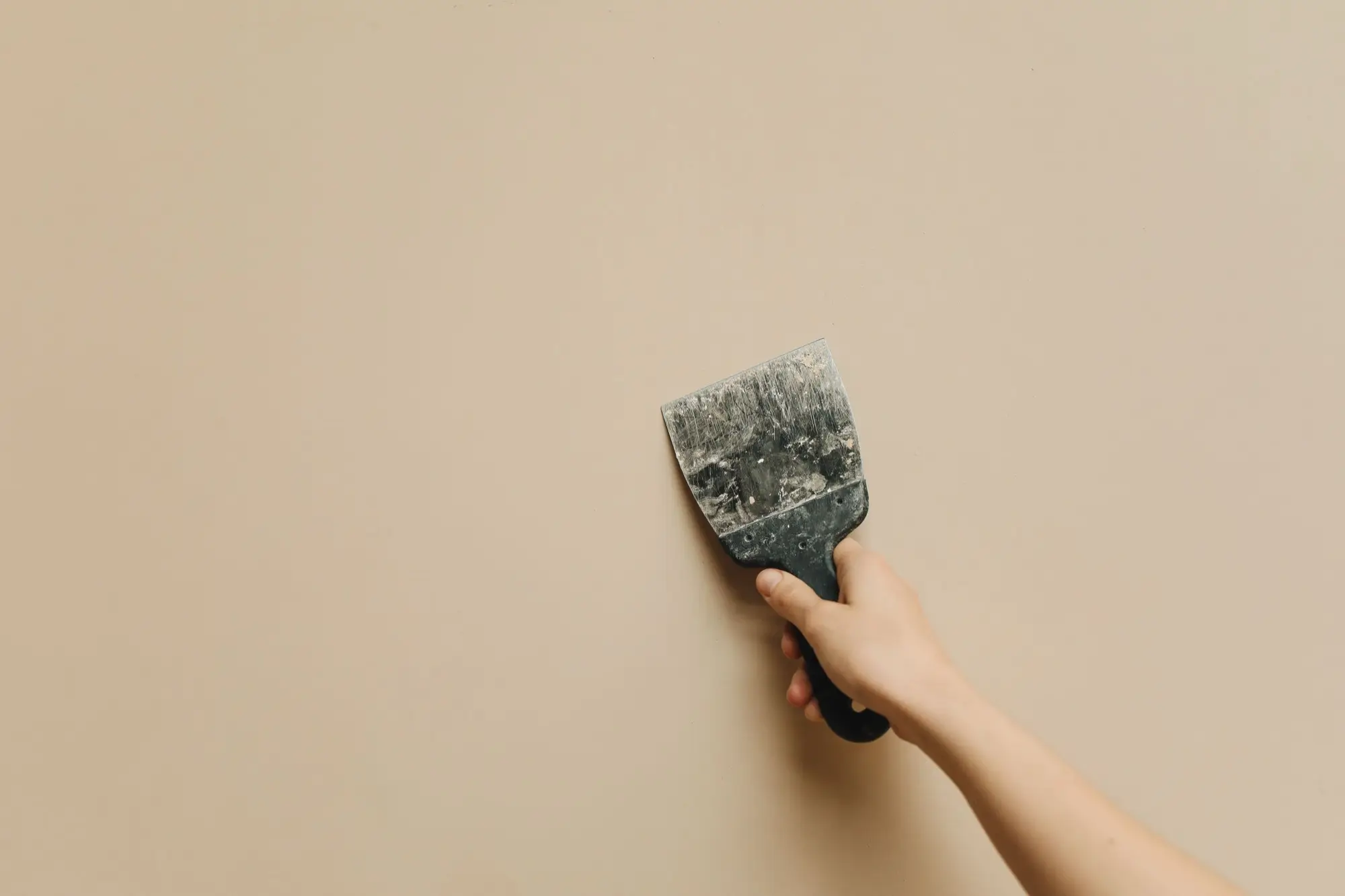 Roller applying fresh white paint across a ceiling