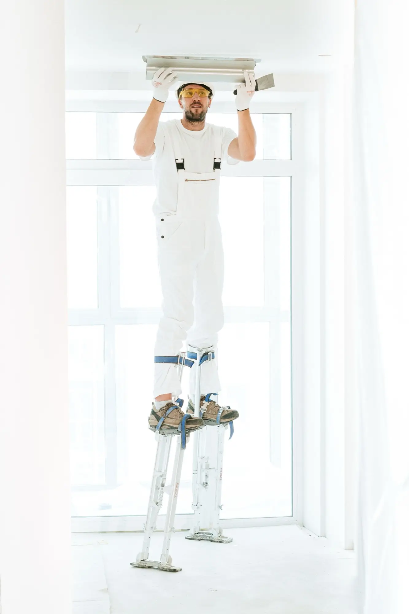 Roller laying an even second coat across a prepared wall