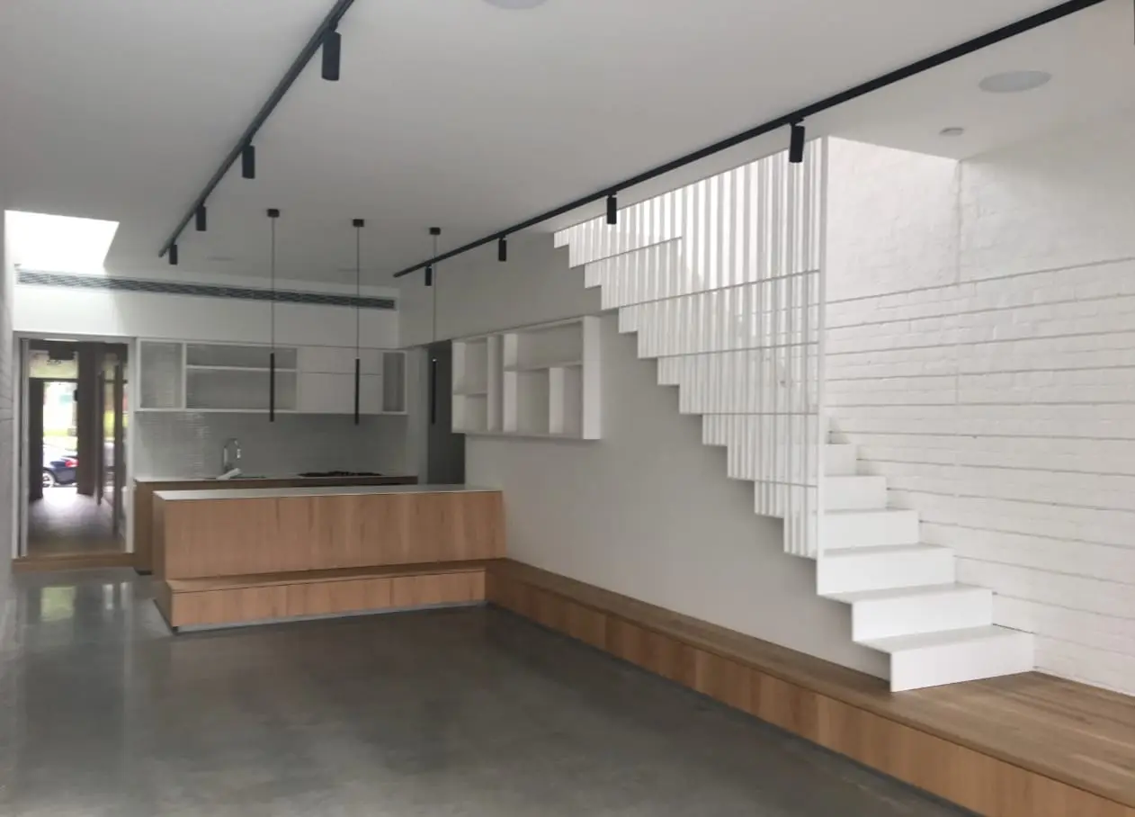 Architectural interior with a white-painted brick wall behind a white staircase